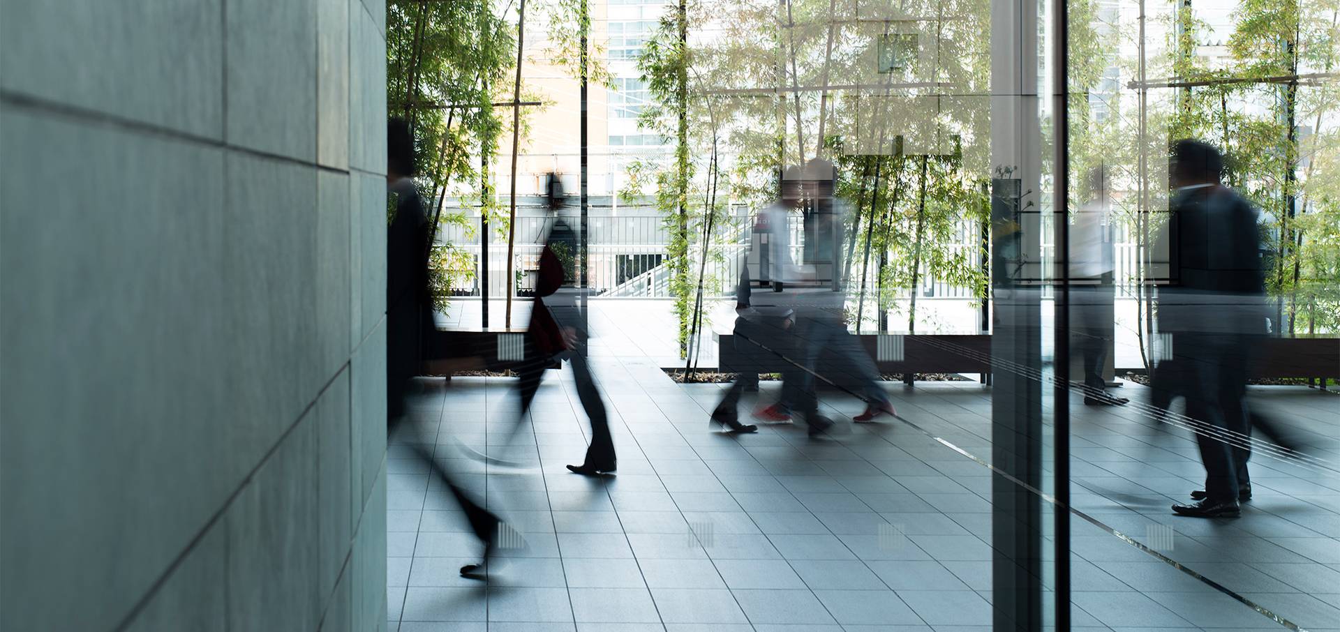People moving through a glass atrium